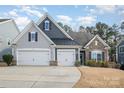 Two-story home with gray and dark siding, two-car garage, and landscaping at 245 Sweet Briar Dr, Fort Mill, SC 29707