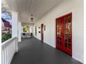 Spacious front porch with red doors, white columns, and a seating area, perfect for outdoor relaxation at 413 W 5Th Ave, Gastonia, NC 28052