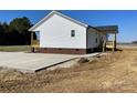 Rear exterior showcasing concrete driveway, backyard and the home's white siding at 4262 Williamson Rd, Rock Hill, SC 29730