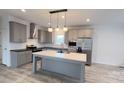 Modern kitchen features a center island, gray cabinets, stainless appliances, and stylish pendant lighting at 507 E Lackey Farm Rd, Stony Point, NC 28678