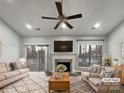 Virtually staged living room with fireplace and sliding glass doors at 7129 Spandril Ln, Charlotte, NC 28215