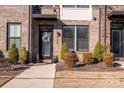 Townhome entrance with a black door, brick facade, and neatly landscaped yard at 824 Broad River Ln, Charlotte, NC 28211