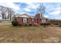 Lovely brick home featuring a traditional style, black shutters, and a cozy front yard at 134 E Andrews St, Norwood, NC 28128