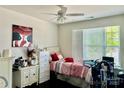 Bright bedroom featuring a ceiling fan, large window, and tastefully chosen decor at 16812 Lookout Landing Ln, Charlotte, NC 28278
