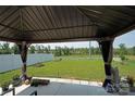 View from under the covered patio of a grassy backyard and treeline at 171 Crownpiece St, Troutman, NC 28166