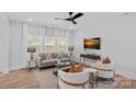 Inviting living room with neutral decor, large windows, and a sleek ceiling fan at 19765 Feriba Pl, Cornelius, NC 28031