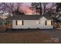 A beautifully presented single-story home with a picturesque sunset backdrop and a cozy front porch at 3411 Rogers St, Charlotte, NC 28208