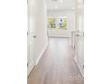 Bright hallway featuring hardwood floors and natural light from the front windows at 3500 Backwater St, Concord, NC 28027