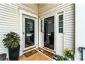 Cozy entryway with glass doors, welcoming mats, and potted plants offers a warm greeting at 7000 Quail Hill Rd, Charlotte, NC 28210