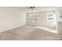 Bright bedroom featuring neutral carpet, ceiling fan, and large windows for natural light at 828 Renee Ave, Fort Mill, SC 29715