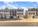 Beautiful street view highlighting a row of townhomes, each with unique facades and attached garages at 828 Renee Ave, Fort Mill, SC 29715