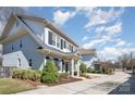 Charming two-story home with light gray brick, dark shutters, and a well-manicured front yard at 1103 N Sharon Amity Rd, Charlotte, NC 28211