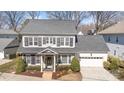 Aerial view of charming two-story home with light gray brick, dark shutters, and a well-manicured front yard at 1103 N Sharon Amity Rd, Charlotte, NC 28211