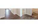 Hallway with wood-look flooring leading to a carpeted bedroom and a tiled bathroom at 135 Jacobs Hill Pl, Troutman, NC 28166