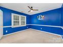 Bright bedroom with fresh blue paint, carpet, ceiling fan, window and white trim; ready for personalization at 2000 Shannon Bridge Ln, Matthews, NC 28105