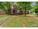Beautiful brick home with mature trees, well-manicured lawn, and a welcoming pathway to the front door at 2000 Shannon Bridge Ln, Matthews, NC 28105