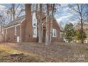 Brick house nestled amongst mature trees, showcasing curb appeal at 2000 Shannon Bridge Ln, Matthews, NC 28105
