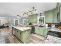 Bright eat-in kitchen with granite counters, modern lighting, stainless appliances and beautiful green cabinets at 2000 Shannon Bridge Ln, Matthews, NC 28105