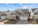 Beautiful home with a manicured lawn, covered porch with chairs, and a convenient two-car garage at 240 Portrait Way # 87, Indian Trail, NC 28079