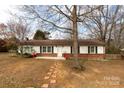 A cozy one-story home featuring white siding, black shutters, and a classic brick base at 550 Brumley Rd, Mooresville, NC 28115