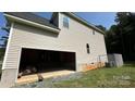 Unfinished attached garage with open door, showing interior framing at 6024 Lake Rd, Mint Hill, NC 28227