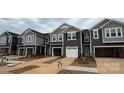 New townhouses with 2-car garages, neutral siding, and landscaping at 7228 Hodges Meadow Ln, Charlotte, NC 28213