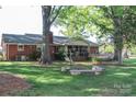 Spacious backyard with a screened-in porch and a cozy fire pit area at 7740 Robinson Church Rd, Charlotte, NC 28215