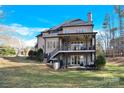 Back exterior featuring a covered porch, large windows, and a well-maintained yard for outdoor enjoyment at 107 E Cold Hollow Farms Dr, Mooresville, NC 28117