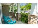 Comfortable front porch features stone pillars, and three aquamarine outdoor chairs at 117 Tomahawk Dr, Mooresville, NC 28117