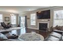 Elegant living room featuring a fireplace, dark wood floors, and a stylish area rug at 117 Tomahawk Dr, Mooresville, NC 28117