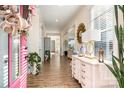 Inviting hallway with a pink door, bright light, hardwood flooring and chic decor, creating an elegant and welcoming entrance at 1575 Riverwalk Pkwy, Rock Hill, SC 29730