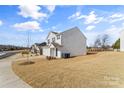 White two-story home's side view, showing yard and neighboring house at 2513 Celestial Dr, Newton, NC 28568