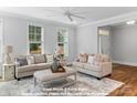 Bright living room with neutral tones, two sofas, an ottoman, large windows and wood floors at 270 Gilead Rd, Huntersville, NC 28078