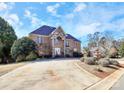 Elegant brick home with a stone facade and arched entrance, complemented by mature trees and a well-manicured lawn at 4029 Wild Nursery Ct, Charlotte, NC 28215