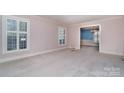 Spacious living area with neutral walls and carpeting, leading to the dining room at 422 Roselawn Pl, Charlotte, NC 28211