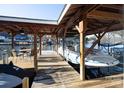 Covered boat dock with ample space for watercraft and relaxing by the lake with a table and chairs at 680 Lake Head Rd, Norwood, NC 28128