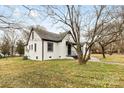 Exterior side view of white brick home featuring black trim and landscaped yard at 912 Hickory Grove Rd, Gastonia, NC 28056