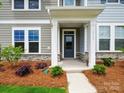 Inviting front porch featuring stone accents and a contemporary front door at 10121 Mamillion Dr, Huntersville, NC 28078