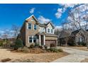 Two-story home with brick and gray siding and a two car garage and landscaping on a sunny day at 1124 Greenbridge Dr, Matthews, NC 28105