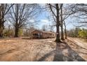 A single-story brick home sits on a spacious lot with mature trees, offering a serene setting at 13501 Mullis Rd, Midland, NC 28107