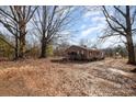 A single-story brick home sits on a spacious lot with mature trees, offering a serene setting at 13501 Mullis Rd, Midland, NC 28107