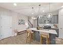 Bright kitchen features gray cabinetry, stainless steel appliances, pendant lighting, and a spacious island with seating at 14041 Whistling Teal Dr, Charlotte, NC 28262