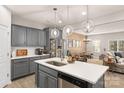 Contemporary kitchen featuring a spacious island, gray cabinetry, and stainless steel refrigerator at 14041 Whistling Teal Dr, Charlotte, NC 28262