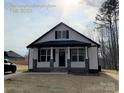 New construction home with white siding, black accents, and a brick base at 401 Fourth St, Stanley, NC 28164