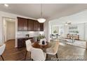 Kitchen and dining area with open floor plan, wood floors, and natural light at 5008 Mooreland Oaks Way # 134P, Mount Holly, NC 28120
