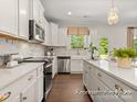 White kitchen with stainless steel appliances and a view to backyard at 5010 Mooreland Oaks Way # 1P, Mount Holly, NC 28120