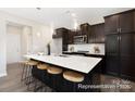 Modern kitchen featuring a large island and dark cabinetry at 5011 Mooreland Oaks Way # 3P, Mount Holly, NC 28120
