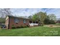 Beautiful brick home with blue shutters, covered porch, and lush green lawn at 5527 Dallas High Shoals Hwy Hwy, Dallas, NC 28034