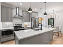 Modern kitchen with stainless steel appliances, quartz countertops, and a stylish chandelier at 625 Colorado Ave # A, Charlotte, NC 28206