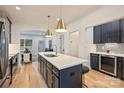 Bright kitchen with navy cabinets, a quartz island with seating, and a view into the adjacent living area at 625 Colorado Ave # B, Charlotte, NC 28206